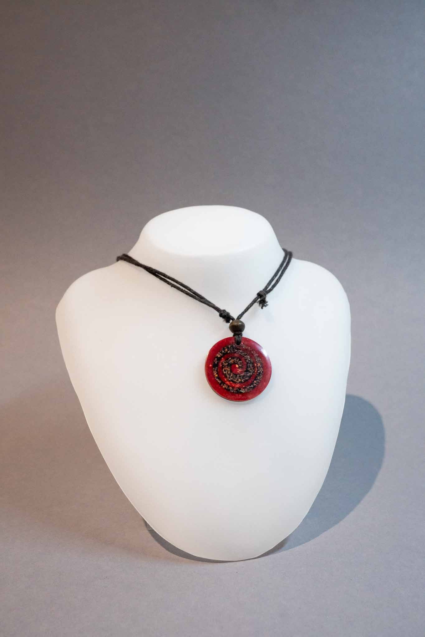 Roter Holzanhaenger mit einmassierter Spirale